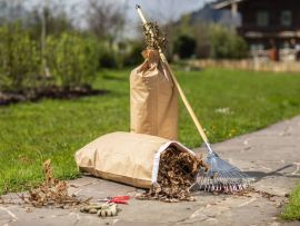 Hände binden einen vollen Papier-Abfallsack zusammen