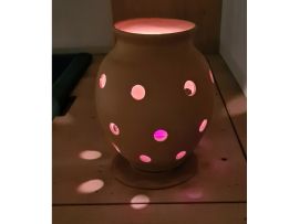 Wurmkomposter mit einer brennenden Kerze darin